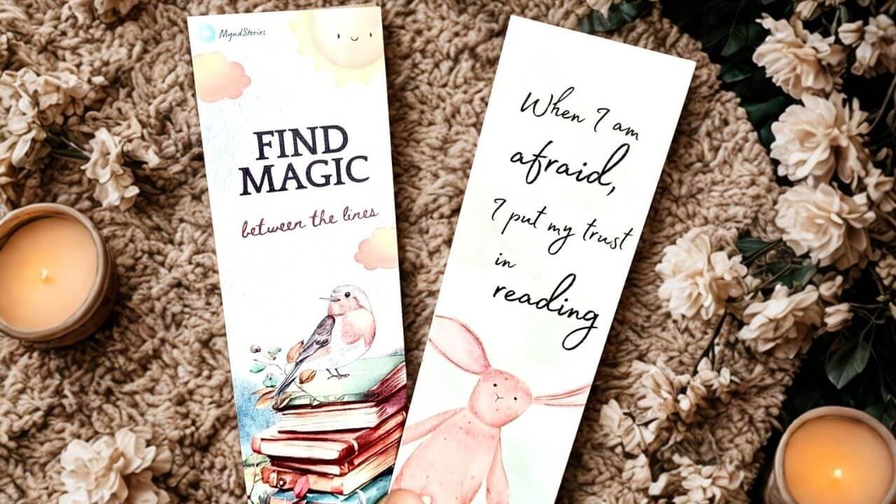 Two illustrated MyndStories bookmarks held over a soft rug with candles